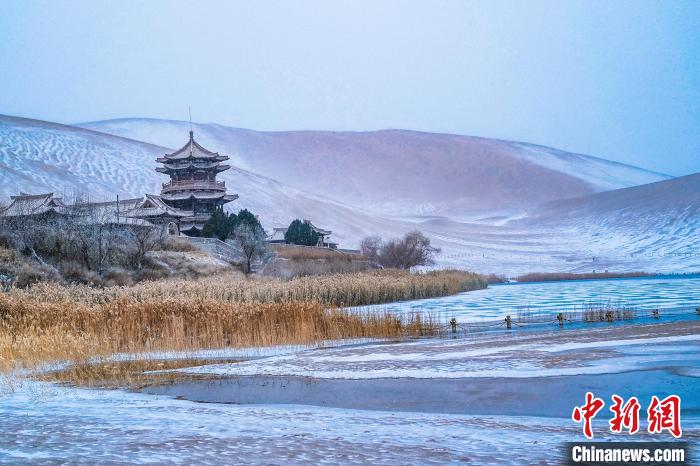 2021年11月28日，雪落鳴沙山月牙泉景區(qū)?！⊥醣筱y 攝