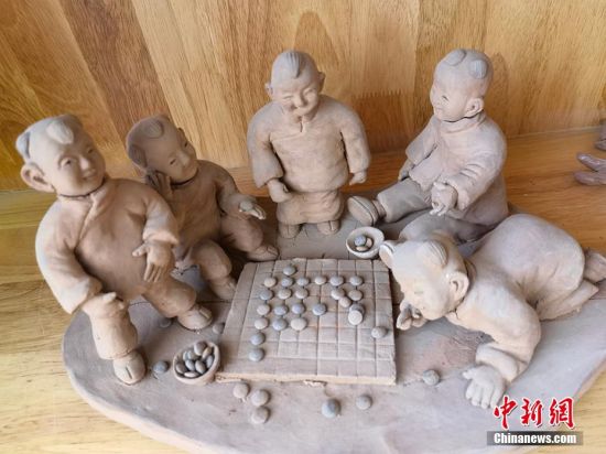 圖為泥塑作品展現(xiàn)下棋場景。 劉玉桃 攝