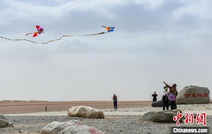 圖為市民正在陽關(guān)景區(qū)放風(fēng)箏。　王斌銀 攝