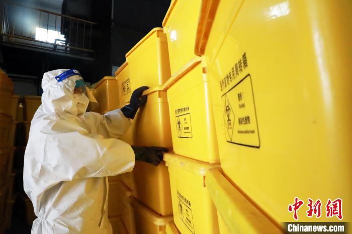 圖為工作人員搬運(yùn)醫(yī)療廢物專(zhuān)用周轉(zhuǎn)箱?！∥航ㄜ?攝