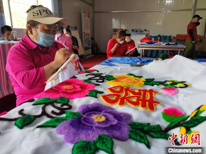 圖為婦女制作青繡?！?zhí)砀?攝
