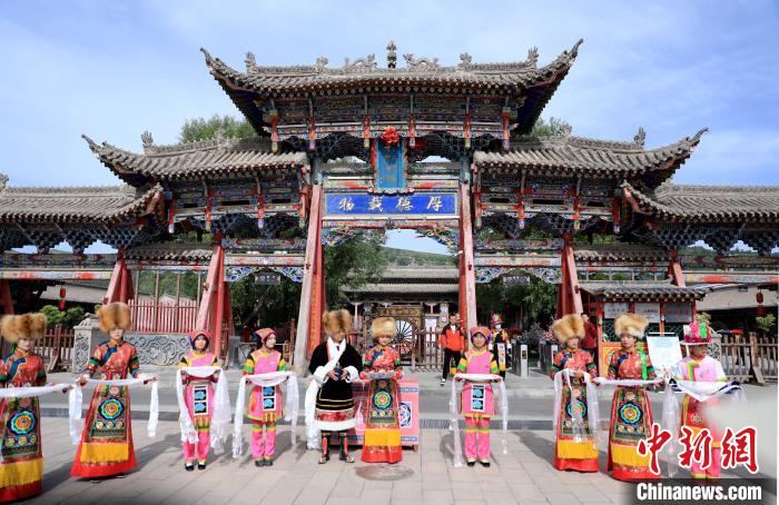 圖為身穿土族服飾的工作人員迎接訪客?！⊙Φ?攝