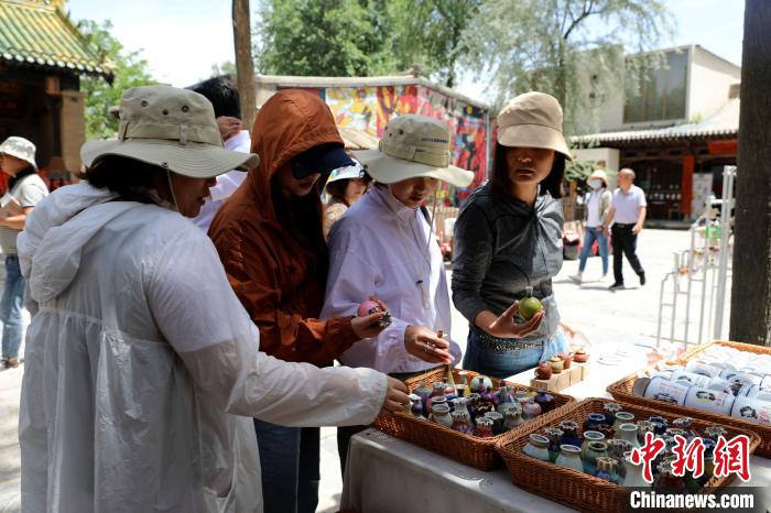 圖為民眾挑選手工藝產(chǎn)品?！⊙Φ?攝