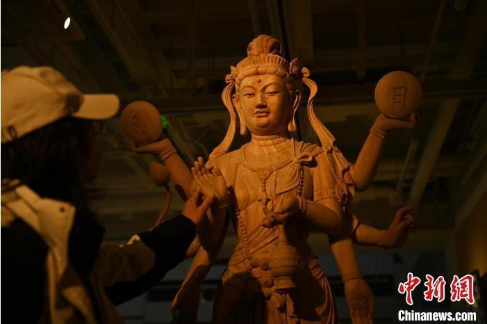 圖為季茂杰觀察自己創(chuàng)作的敦煌木雕。李亞龍 攝</p>
<p>