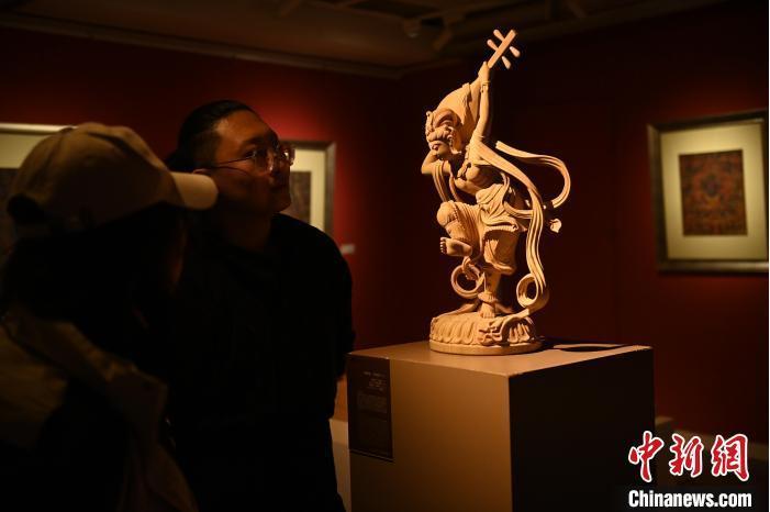 圖為季茂杰向參觀者介紹自己創(chuàng)作敦煌木雕的過程。李亞龍 攝</p>
<p>