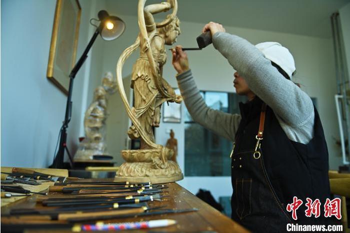 圖為季茂杰進(jìn)行敦煌元素的木雕創(chuàng)作。李亞龍 攝</p>
<p>