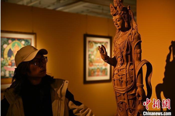 圖為季茂杰觀察自己創(chuàng)作的敦煌木雕。李亞龍 攝</p>
<p>