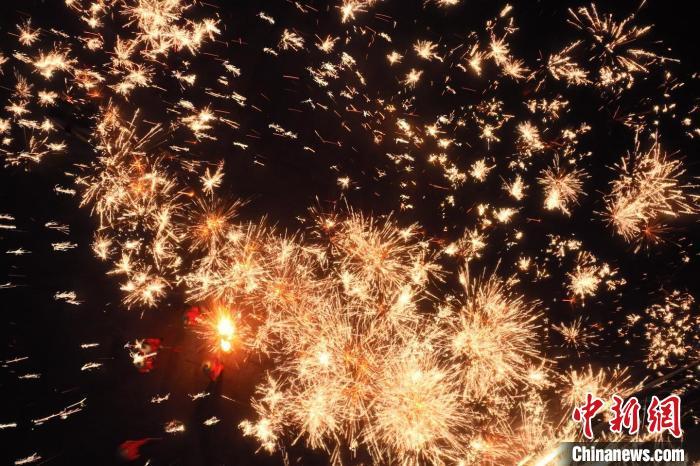 灼熱的鐵水在空中迸散。在空中形成“鐵花火雨”的景象，似天女散花，似群星漫天，如夢如幻，美不勝收。侯奇志 攝</p>
<p>