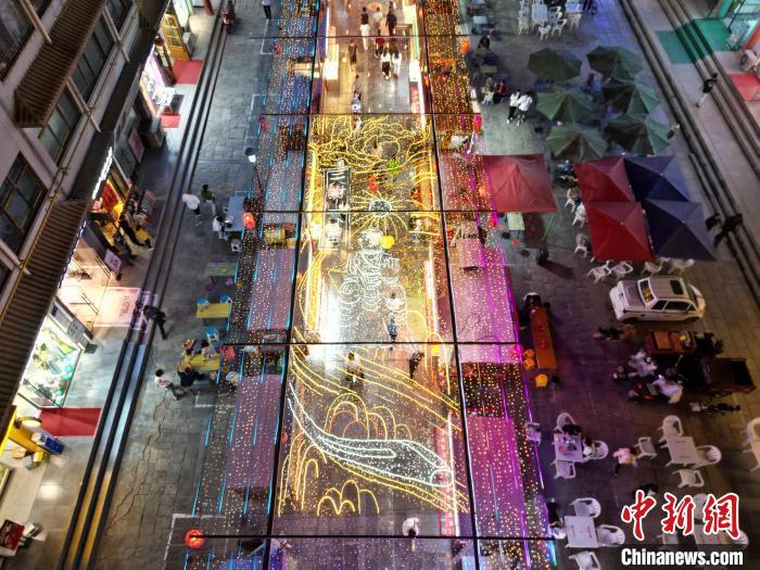 圖為明清街夜市燈光點亮具有武威文化元素的“天梯山石窟”彩燈。(無人機照片) 　戴文昌 攝</p><p>