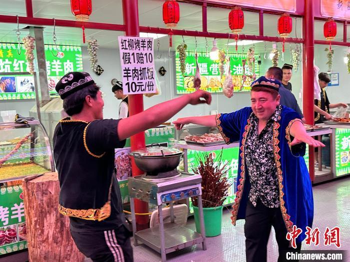 圖為餐飲經營者在“西涼不夜城”跳起舞蹈引客?！〈魑牟?攝</p><p>